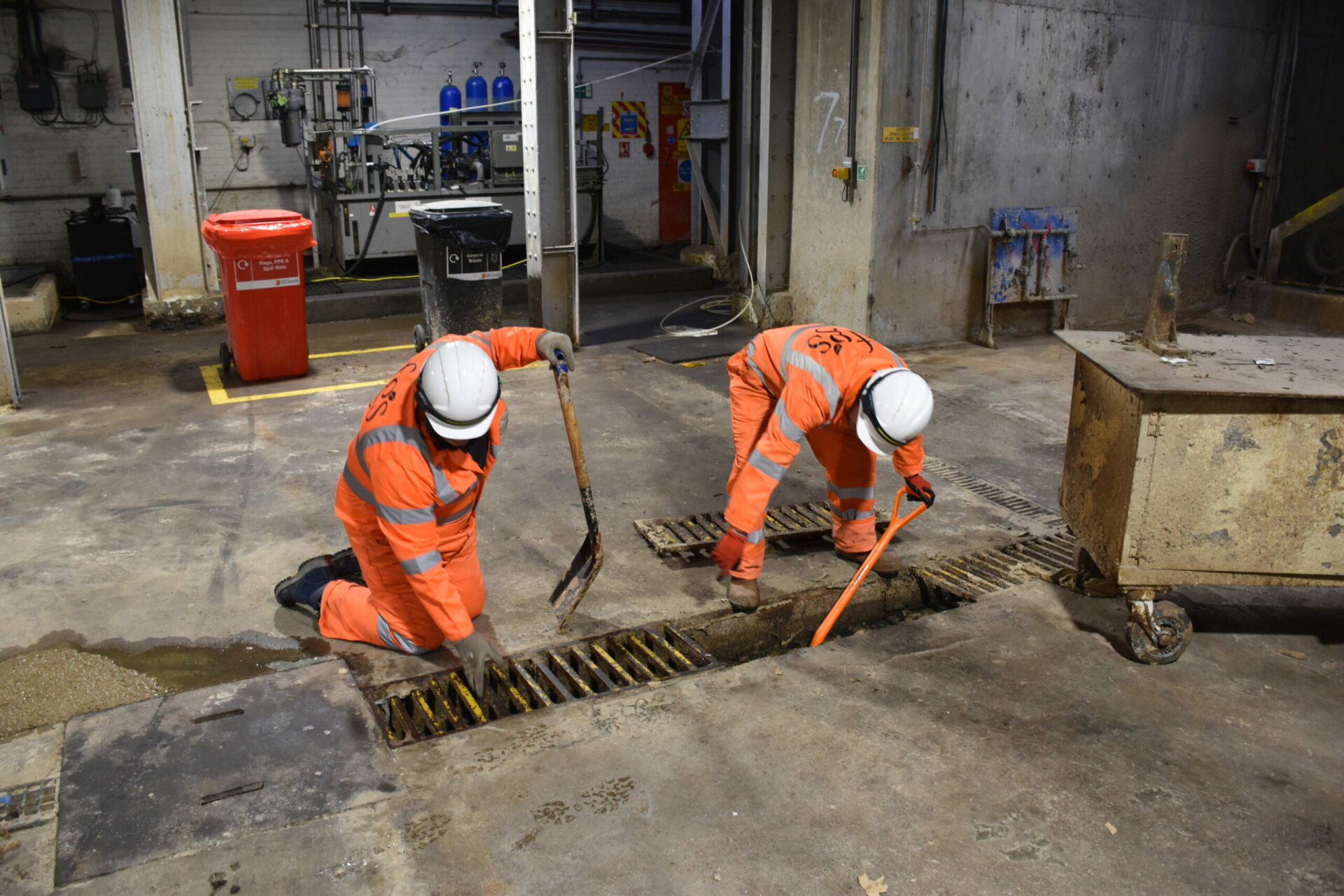 Labour supply operatives at work cleaning out a drain